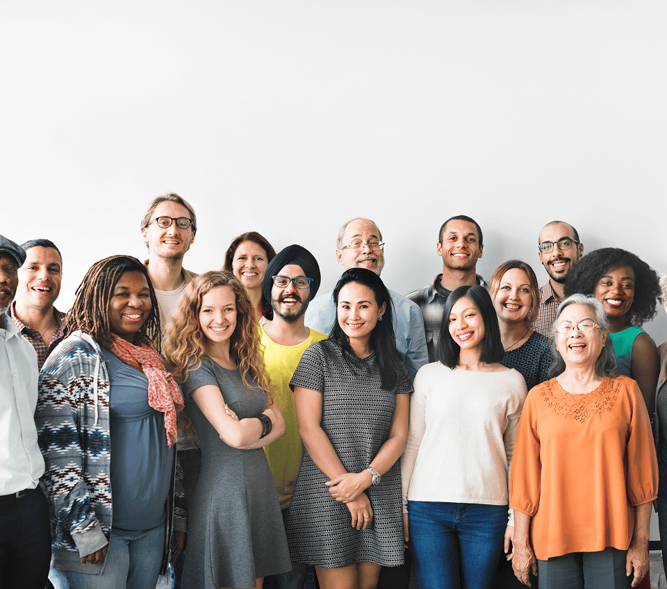 A diverse group of professionals smiling together in a bright, modern setting.