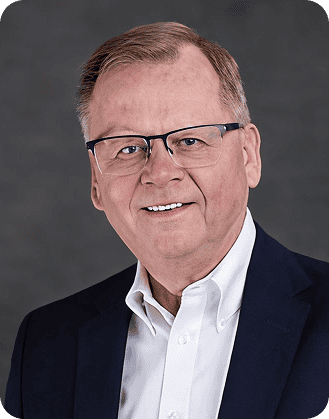 High-quality professional portrait of a mature man in business attire, smiling confidently.
