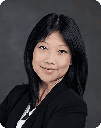 High-quality professional portrait of a woman with black hair in a black blazer, smiling confidently.