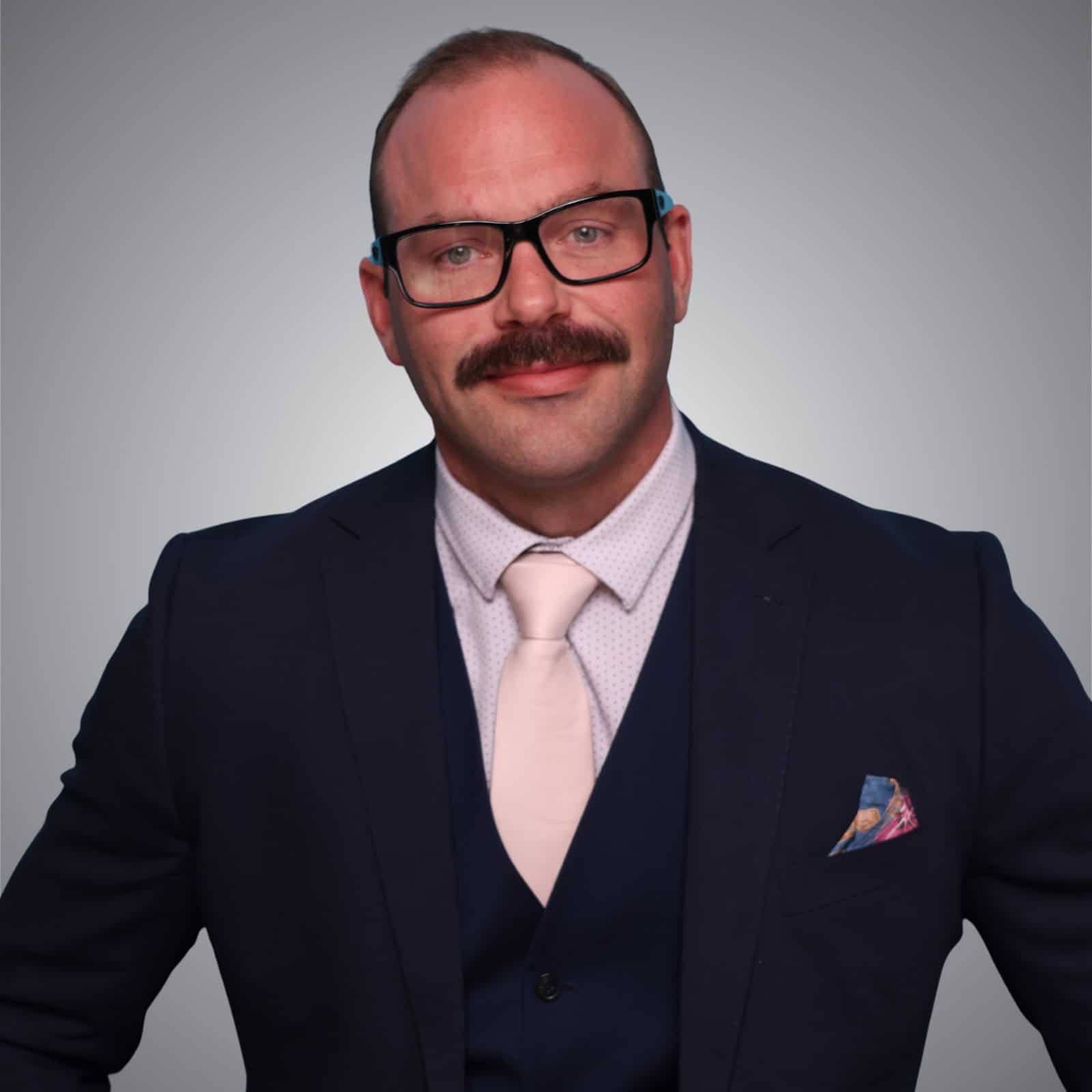 Portrait of a professional man in a suit and glasses, representing Canadian Hospital Specialties Ltd.