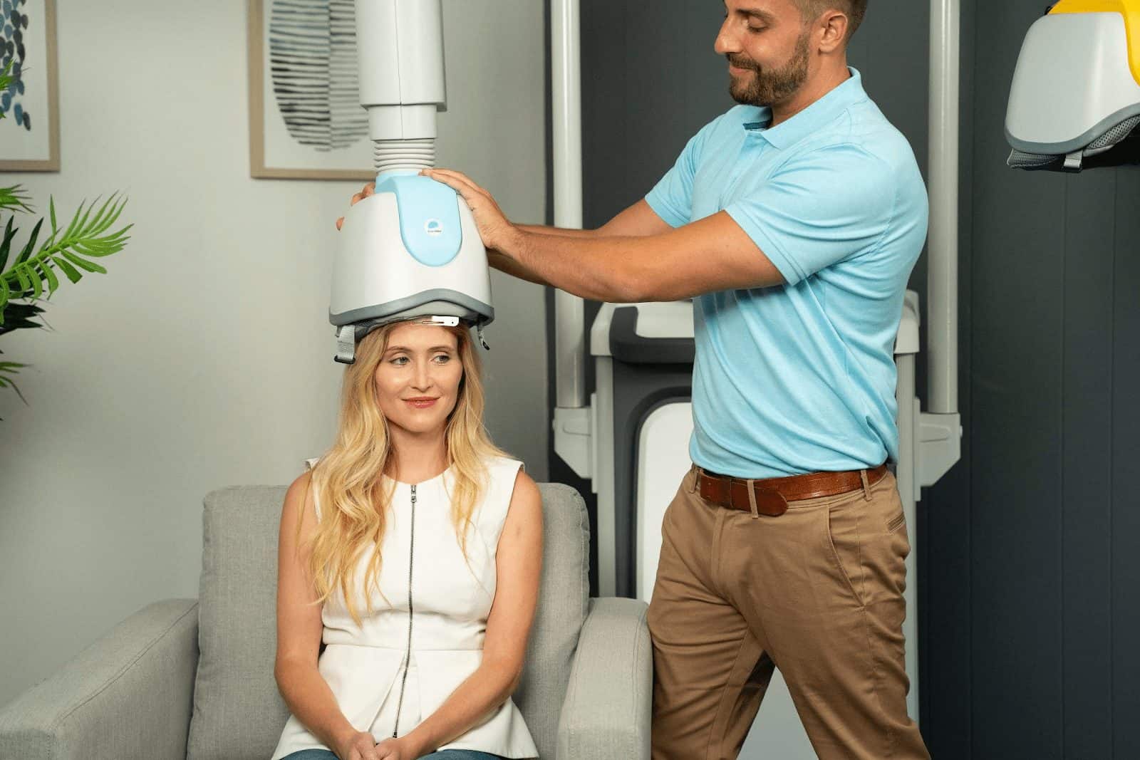 Medical professional operating imaging equipment with a patient in a clinical setting.