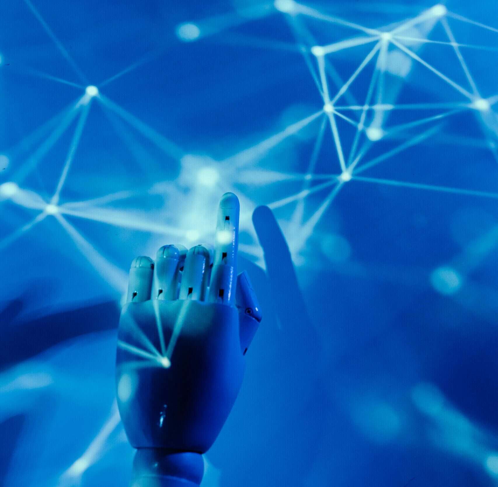 AI-powered robotic hand interacting with a digital network of interconnected nodes and lines.